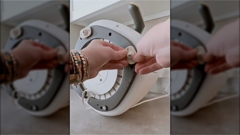 woman applies casters to appliance