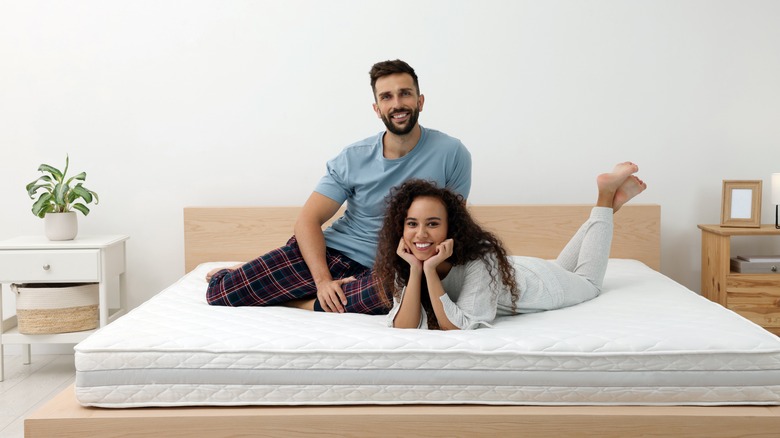 Smiling couple on clean mattress