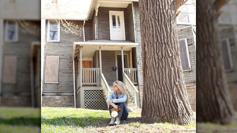 Nicole Curtis sitting by tree