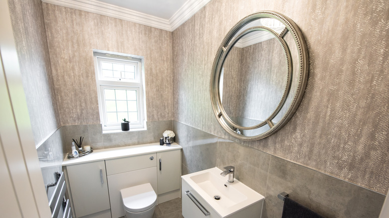 Small luxurious bathroom with crown molding.