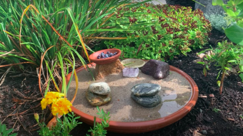 Terracotta butterfly puddler in garden