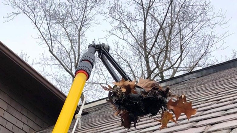 A grabber picking up a bunch of dry leaves