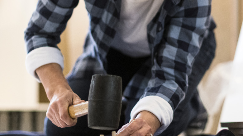 Person using rubber mallet