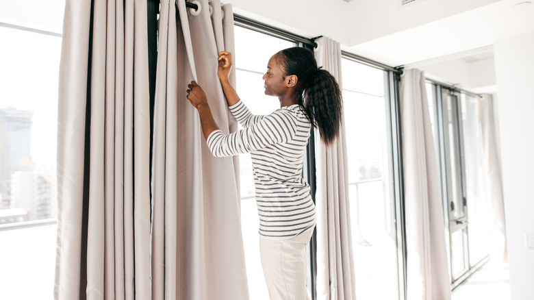 woman hanging windows at home