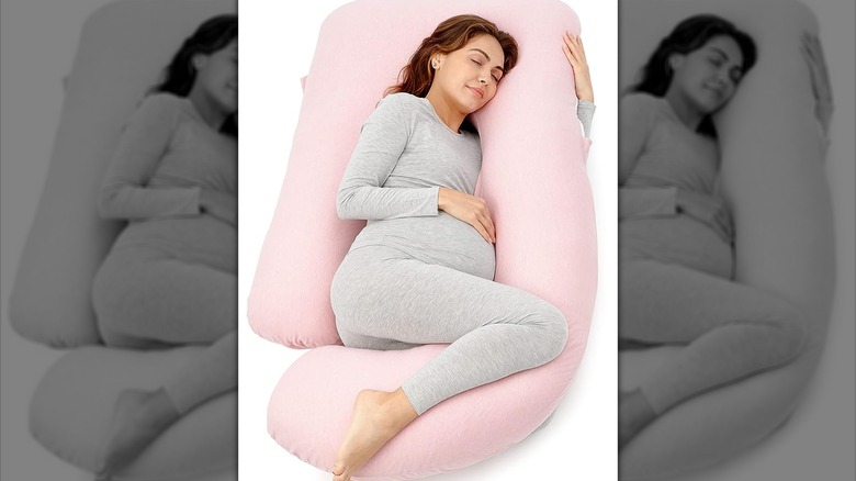 Pregnant woman sleeping with body pillow