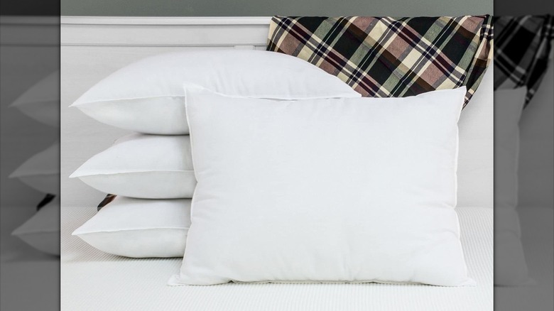 Four white pillows on bed