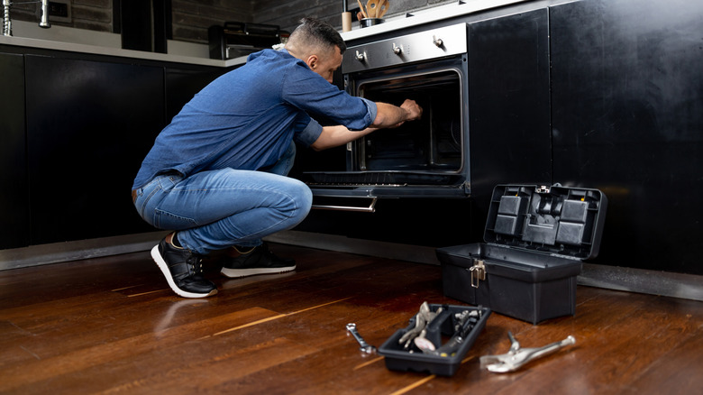 Man repairing broken oven