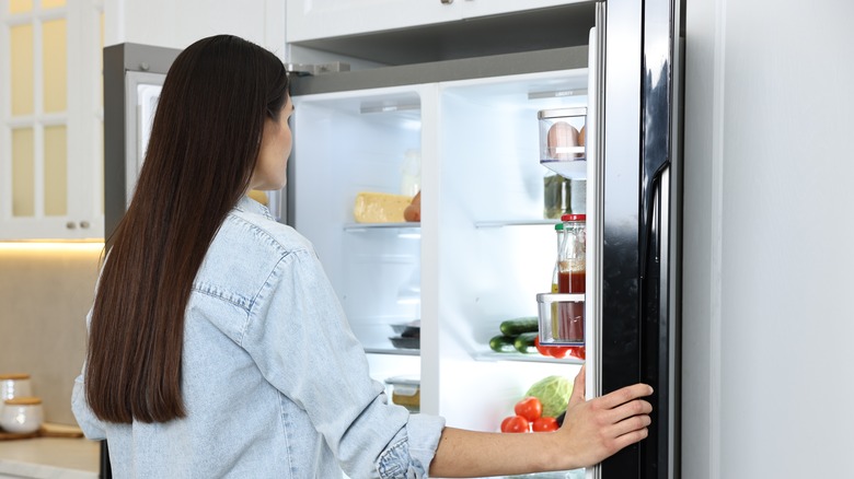 Woman looking into refrigerator