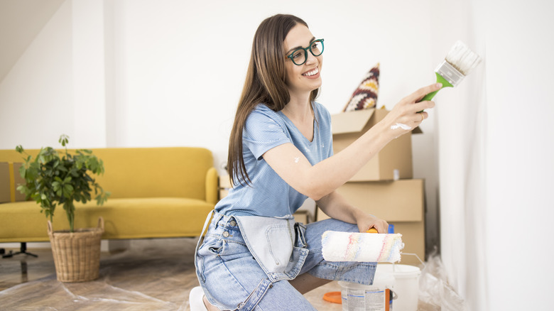 Woman painting a wall white