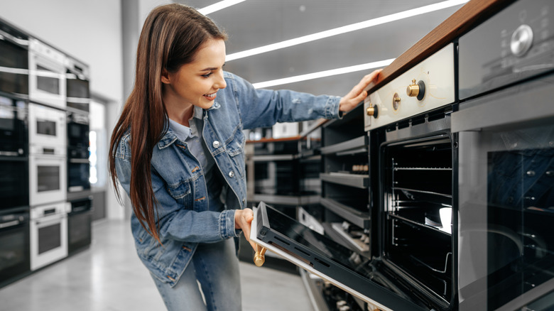 Woman smiling while shopping for oven