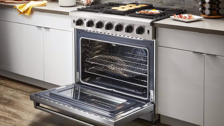 Thor six burner gas range with door open in modern kitchen