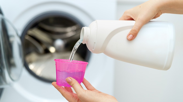 Pouring liquid detergent in cup