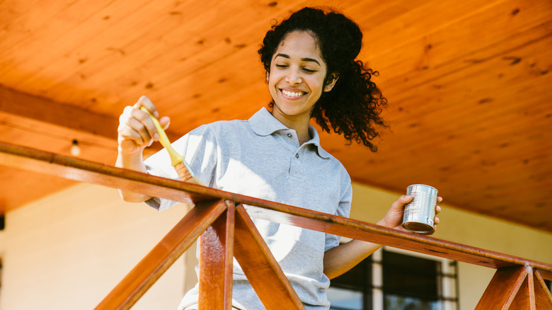 woman staining a wooden deck