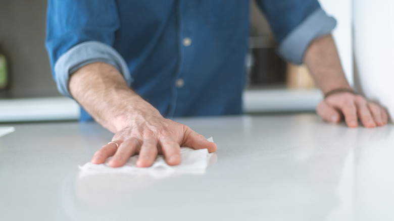 person cleaninng kitchen countertop