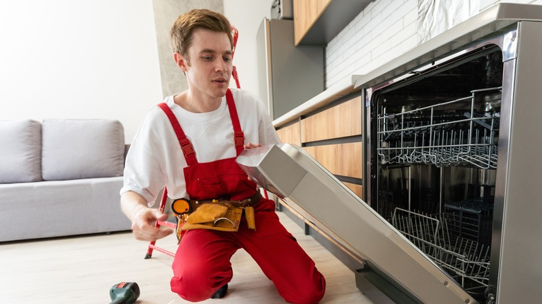 A person is fixing a dishwasher