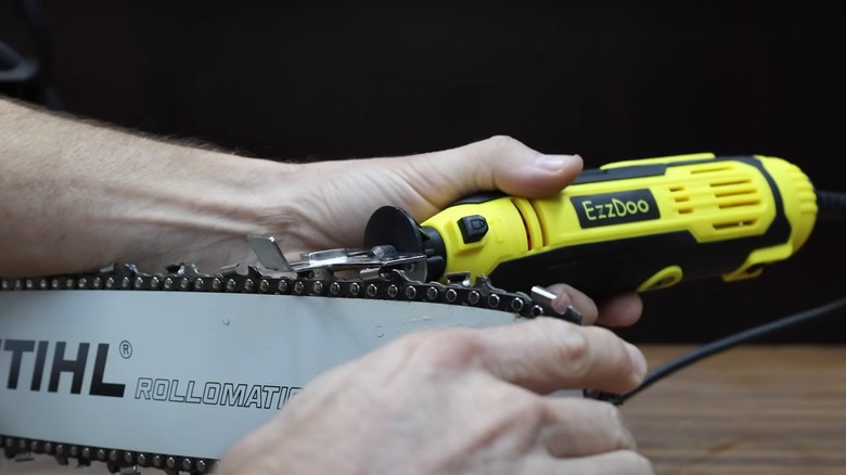 sharpening a chainsaw with a powered tool