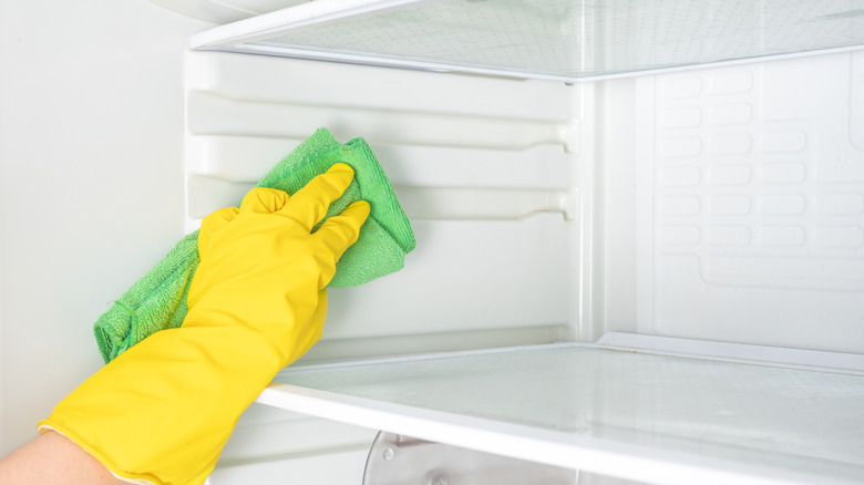 person deep cleaning freezer