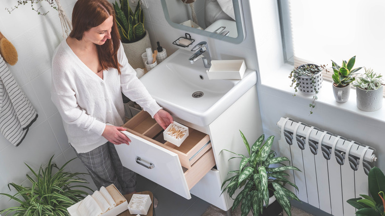 woman decluttering bathroom vanity drawer