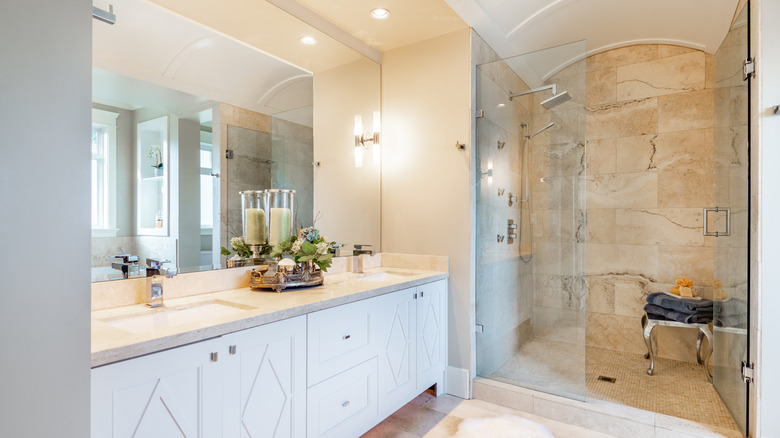 A large, light bathroom with a travertine shower