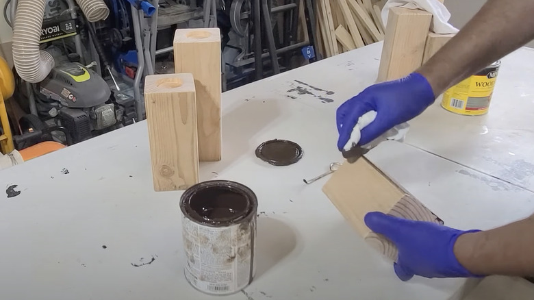 person staining wood blocks