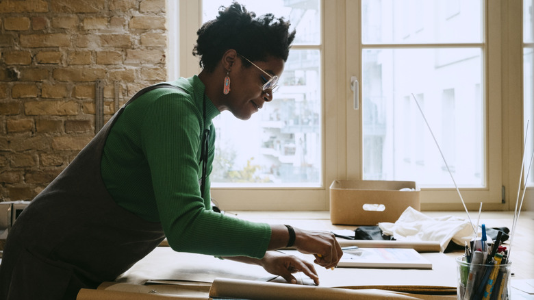 Woman working on DIY project bent over table