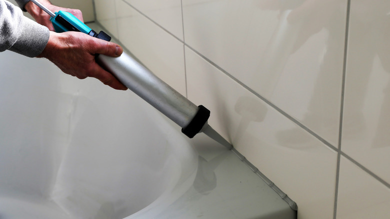 Person caulking bathtub