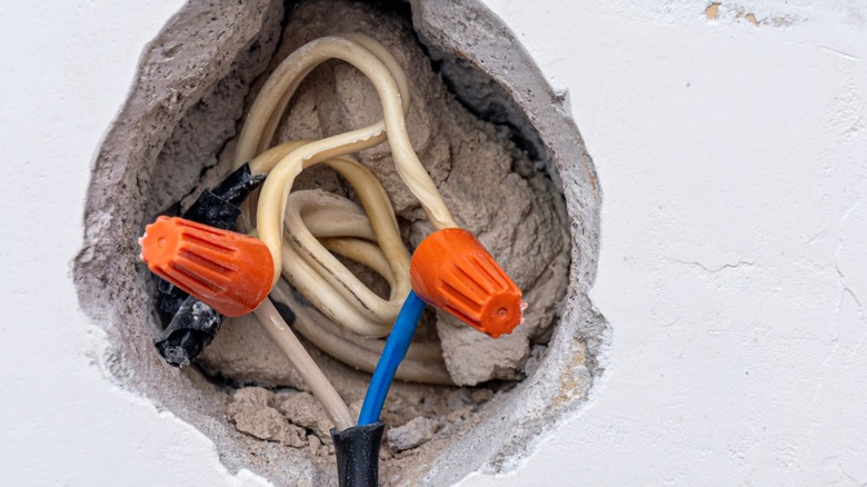 Two orange wire nuts connecting wiring in concrete wall