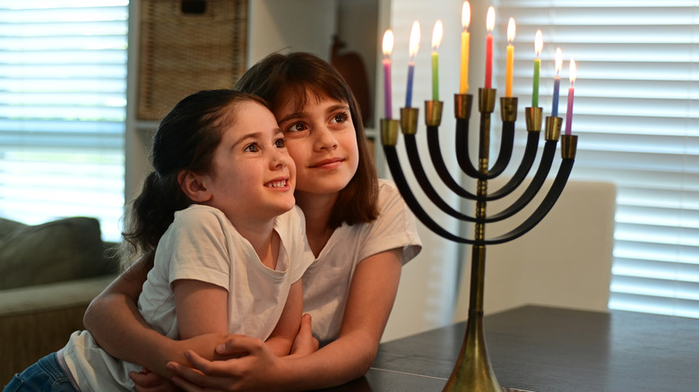 Children looking at brass menorah