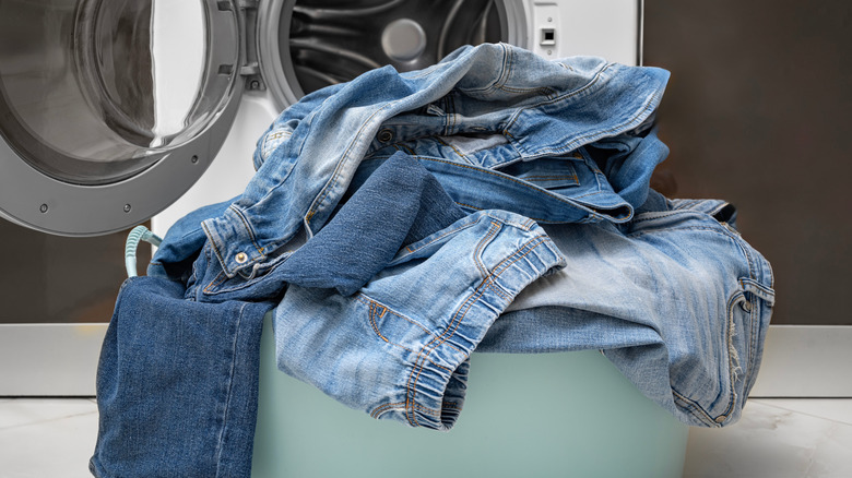 Pile of denim in front of laundry machine