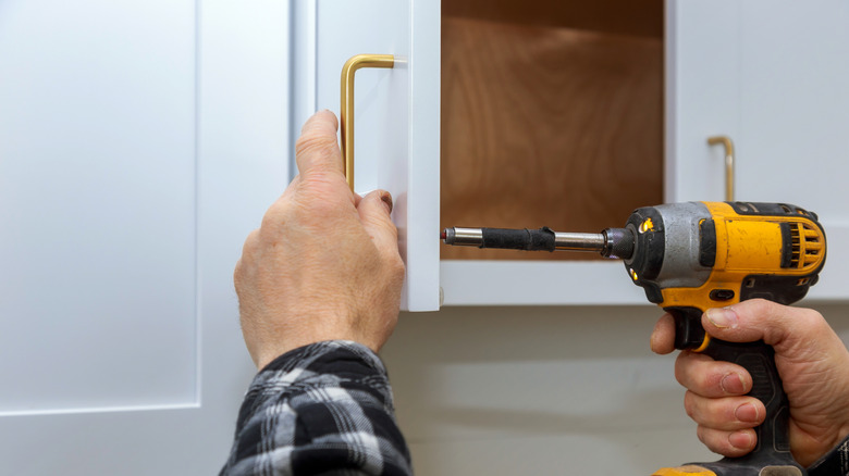 Handyman replacing kitchen cabinet handles