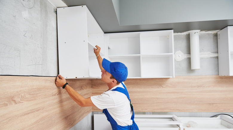 worker installing kitchen cabinets