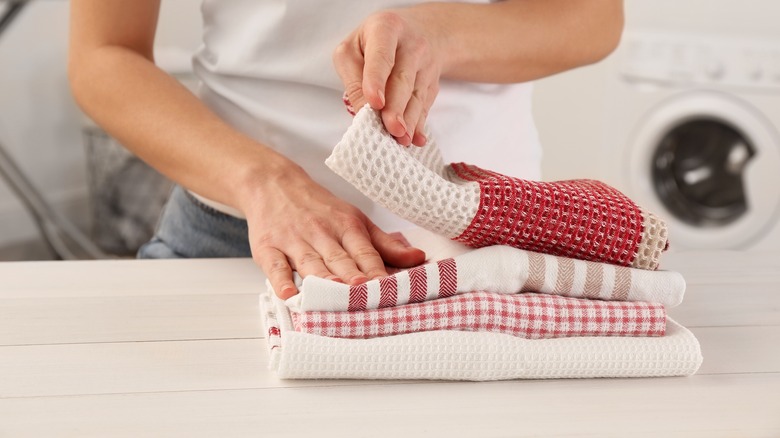 hands folding clean red kitchen towels