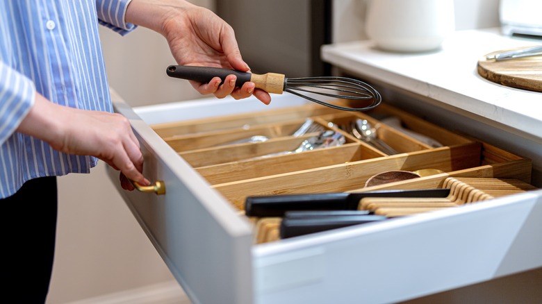 woman opening organized kitchen drawer