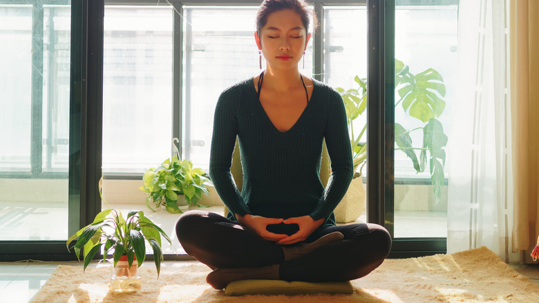 woman meditating on a cushion