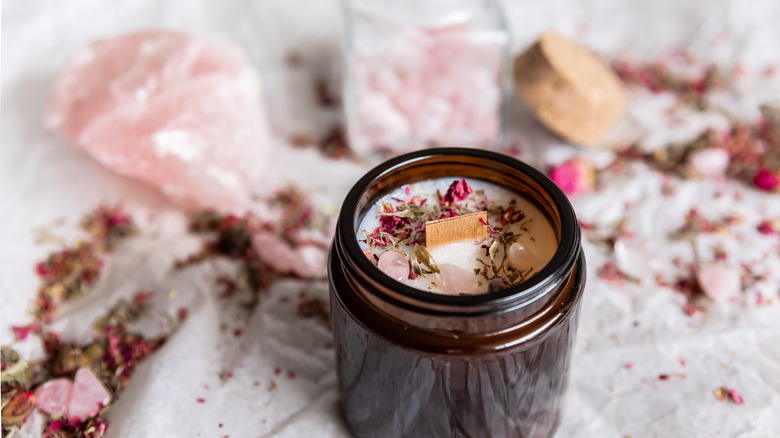 candle surrounded by rose quartz crystals 