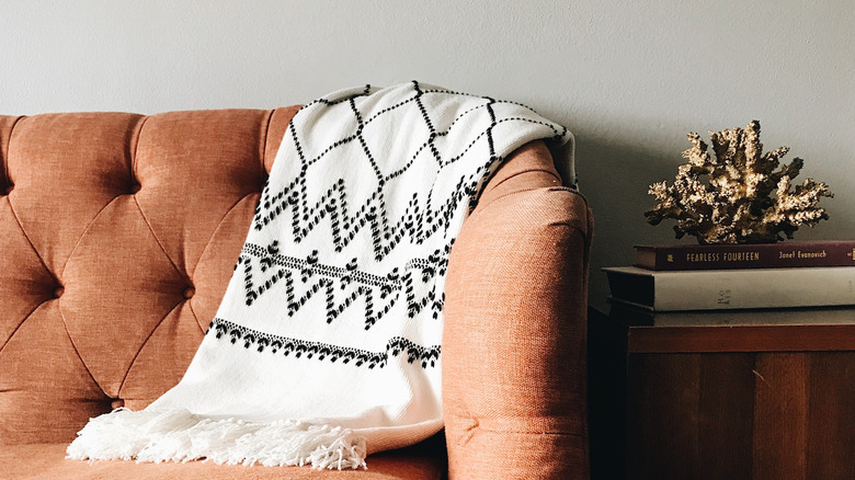 patterned blanket on orange sofa