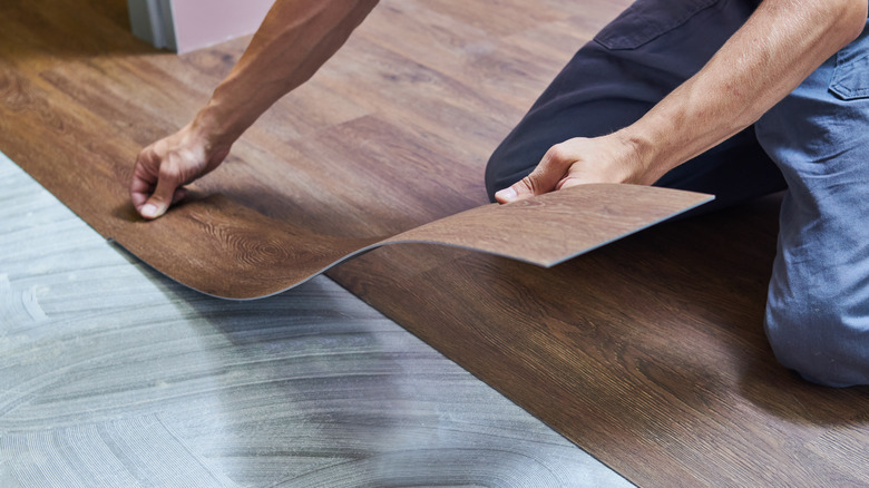 man installing vinyl wood flooring 