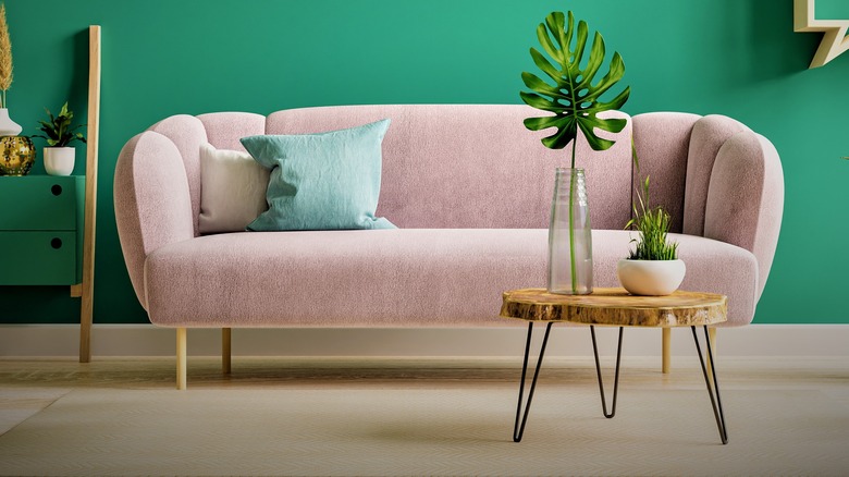 pink couch against green wall