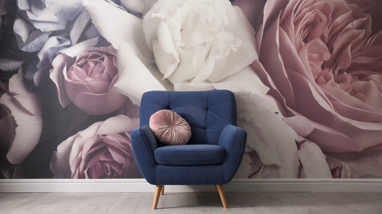 rose wallpaper behind a blue chair