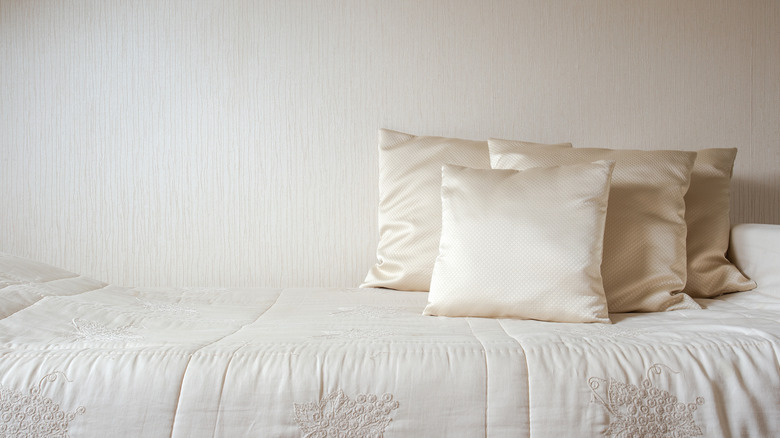 silk and cotton texture on bed against grasscloth walls