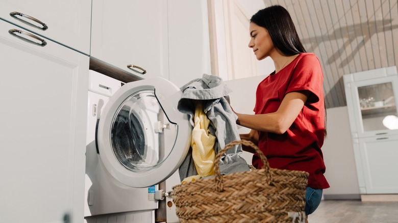 woman loading laundry machine 