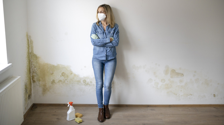 person leaning on water damaged wall