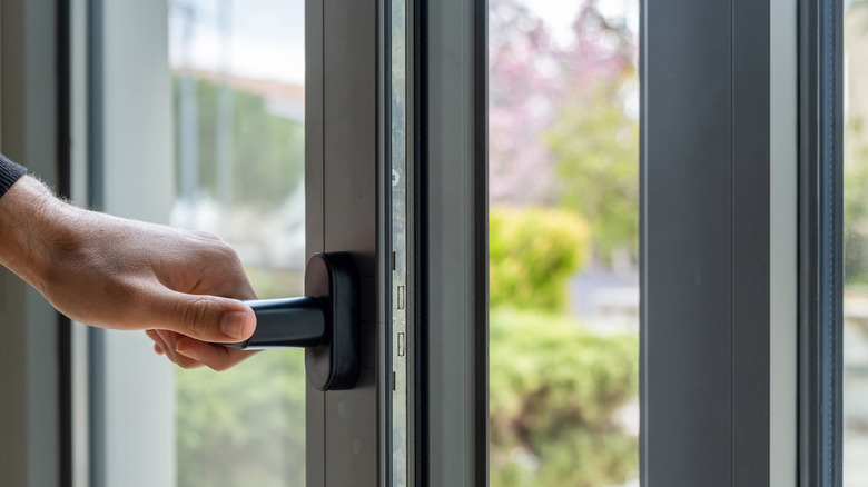 man closing window with handle