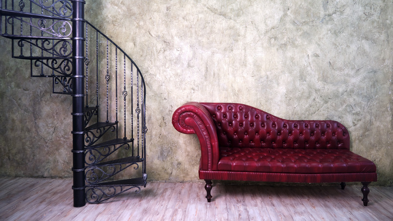 spiral staircase with curved vintage couch