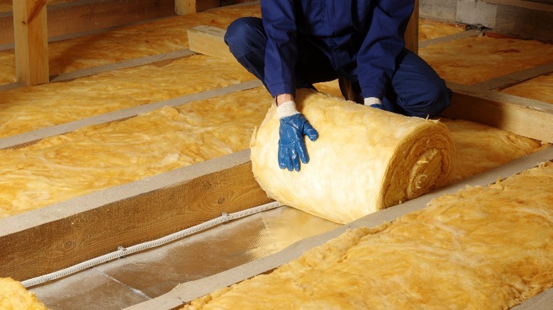 person laying roof insulation 