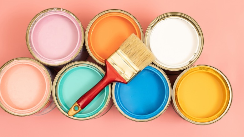 open paint cans on coral background 