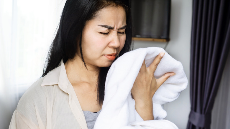 person smelling stinky towel