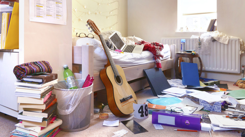 Messy bedroom with papers and clothing