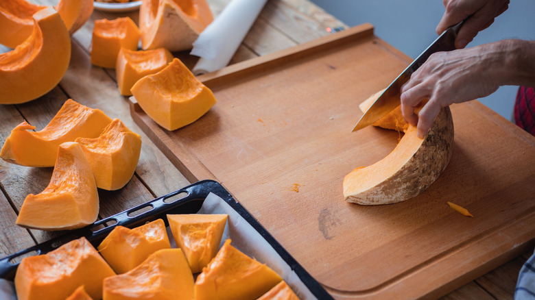 Person cutting pumpkin into pieces