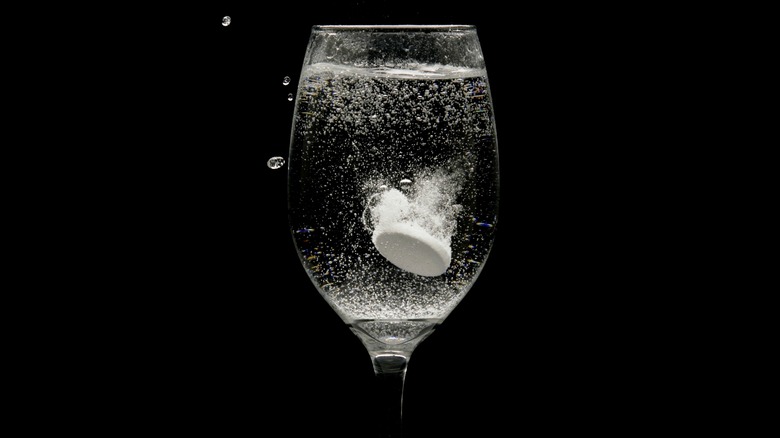 Alka-seltzer tablet fizzing in glass